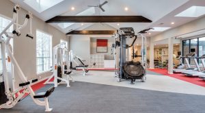a gym room with a red carpet and white walls at The Hyde Park at Valley Ranch