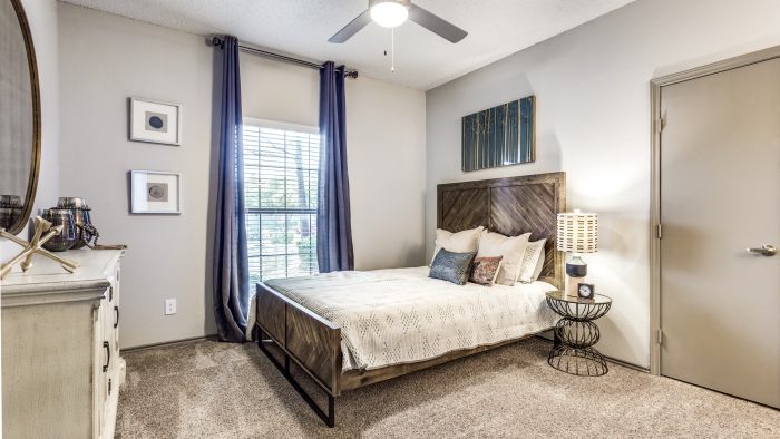 a bedroom with a ceiling fan and carpeted floor at The Hyde Park at Valley Ranch